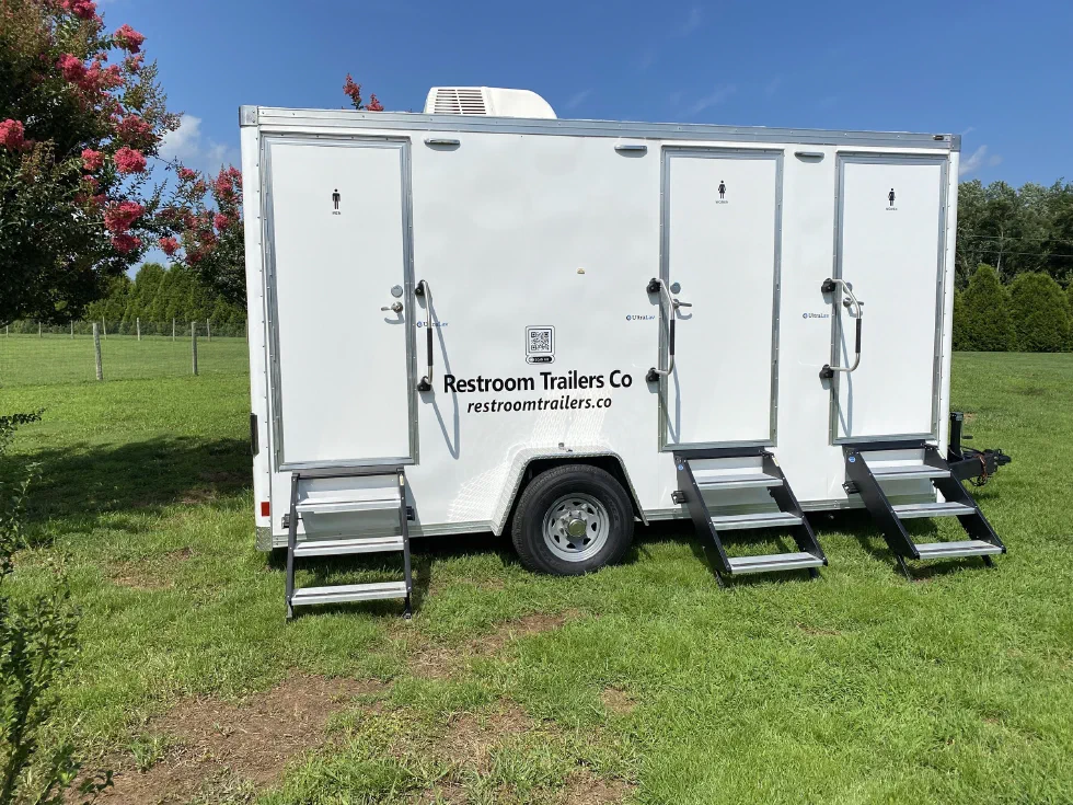 Three-station restroom trailer with steps down at each door